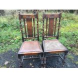 A pair of carved oak chairs, the back rails with oval flowerhead medallions above slats framed by