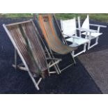 A pair of folding deck chairs, the striped canvas seats knackered; and a pair of folding hardwood