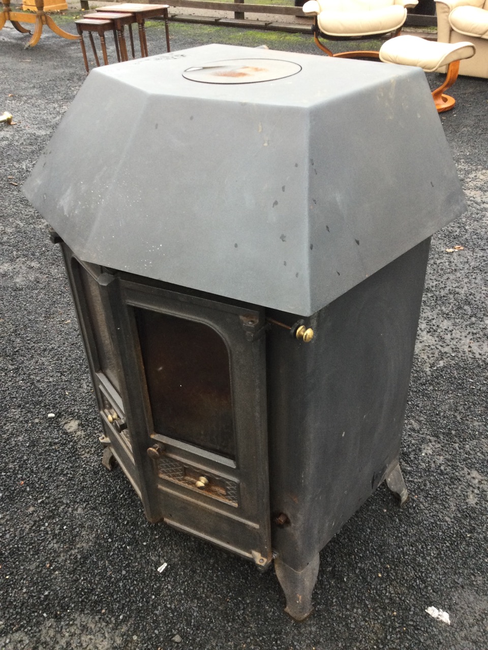 A cast iron wood/solid fuel stove with angled glazed doors having fitted back boiler, raised on