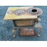 A rectangular cast iron stove, the oven with drop-down door, raised on cabriole legs. (25in x 14.5in