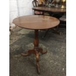 A C19th mahogany drop-leaf circular occassional table raised on baluster turned column, with