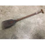 An antique hardwood shovel with elm handle, the blade with forged metal plates, the shaft with
