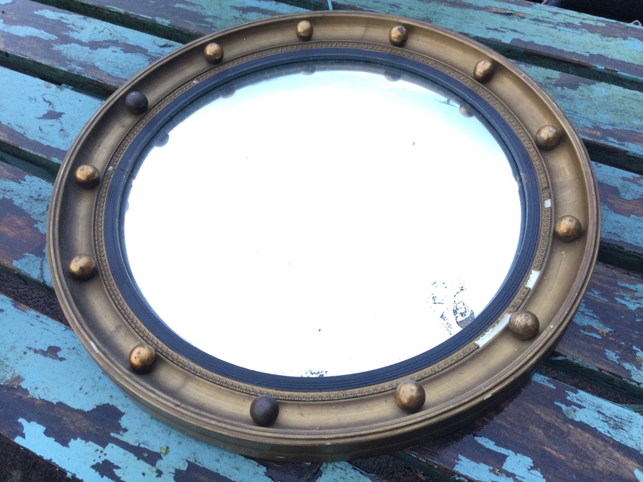 A circular Regency style gilt convex mirror, the concave moulded framed mounted with balls, having