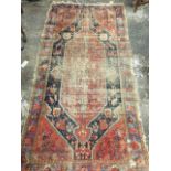 An oriental rug woven with rectangular floral panel with pendants in dark blue field, the red