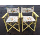 A pair painted folding director style garden armchairs, with webbed cushion seats and platform arms,