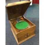 An oak cased His Masters Voice wind-up gramophone, with rectangular moulded top above a cabinet with