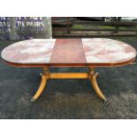 A Georgian style yew dining table, the top inlaid with ebony stringing on twin baluster turned