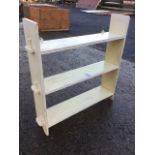 A painted set of hanging shelves with ribbed borders, the platforms pegged to uprights. (26in x 25.