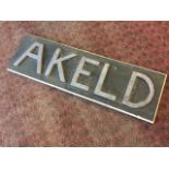 An Akeld sign made up in lead, on a rectangular painted pine board. (38.5in)