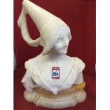 A French carved carerra marble bust of a young lady wearing traditional hat & dress, on moulded