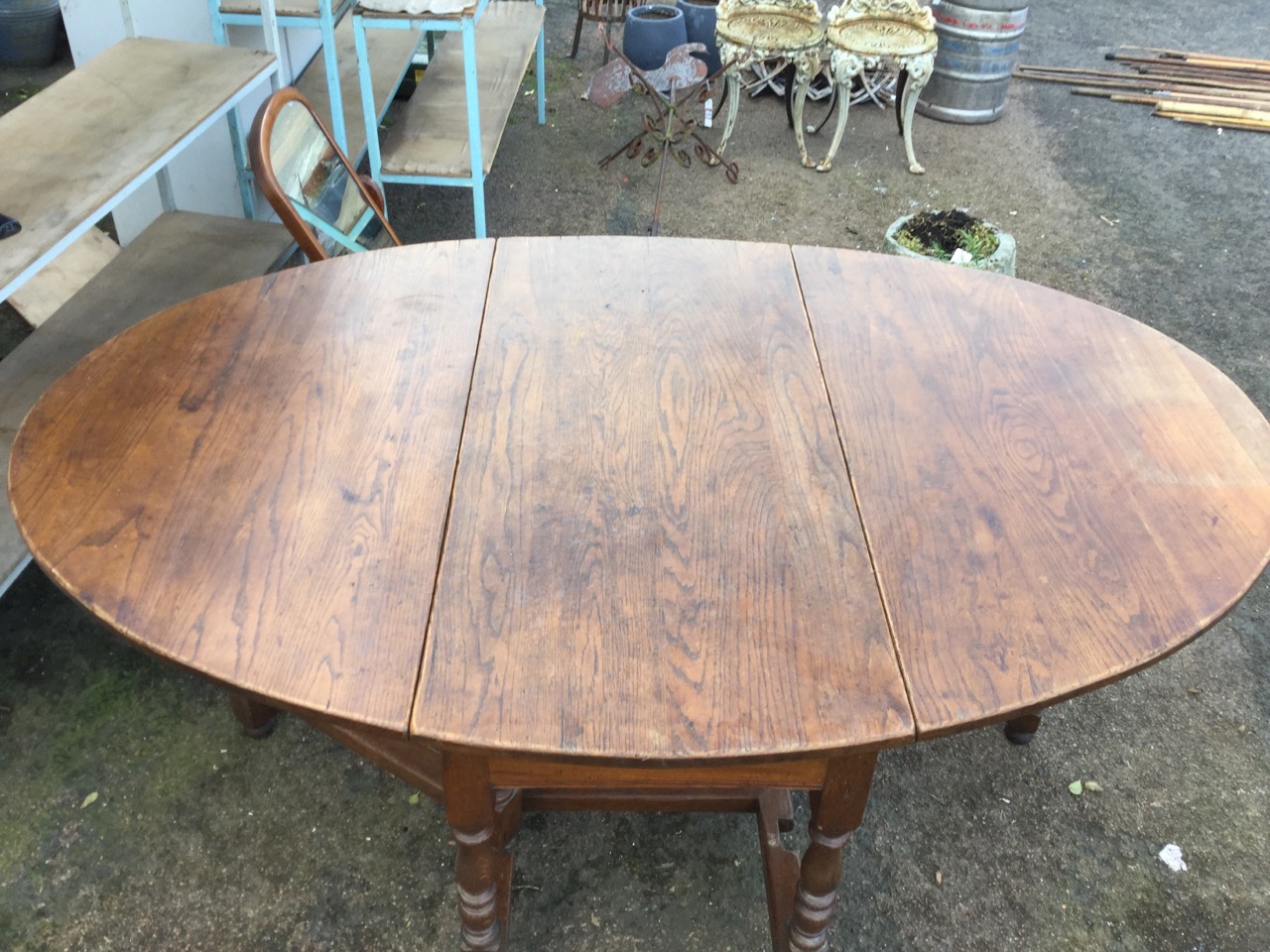 An oval oak dining table, the top with two drop leaves supported on baluster turned columns joined - Image 2 of 3