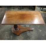 A Victorian mahogany serving/reading table, the rectangular moulded top on a rise-and-fall column