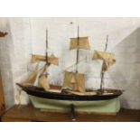 An early C20th three-masted model schooner, the boat on stand with original sails, masts, cedar