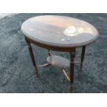 An oval mahogany occasional table, the moulded top on reeded column legs with applied floral