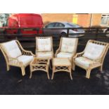 A cane conservatory suite with floral loose cushions to latticework armchairs, with twin square