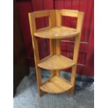 A folding pine corner stand with three bowfronted shelves. (37in)