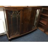 A bowfronted mahogany china cabinet with moulded top above central door flanked by astragal glazed