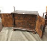 A William & Mary walnut spice cabinet, with feather crossbanded doors enclosing an interior with