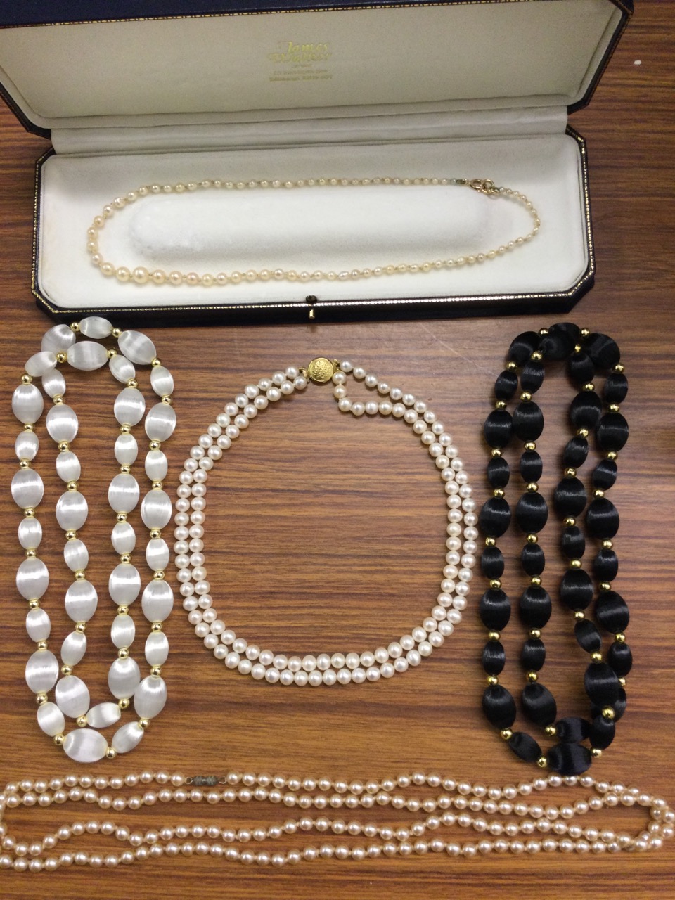 A cased double-strand pearl choker with 9ct gold bun shaped embossed clasp; a pair of silk black &