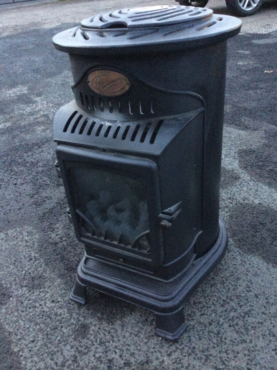 A Provence portable gas stove, the tubular case for gas bottle behind a hinged glazed door, raised