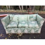 A Knole house three-seater sofa with padded back and loose cushions having drop-down arms, the