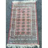 A silk style rug woven with pink field of twenty seven lozenges within a star border, the ends