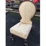 A Victorian mahogany nursing chair with wide round moulded and waisted back above a cushion seat,