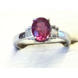 An 18ct white gold pink sapphire & diamond ring, the oval claw set sapphire weighing over one-and-