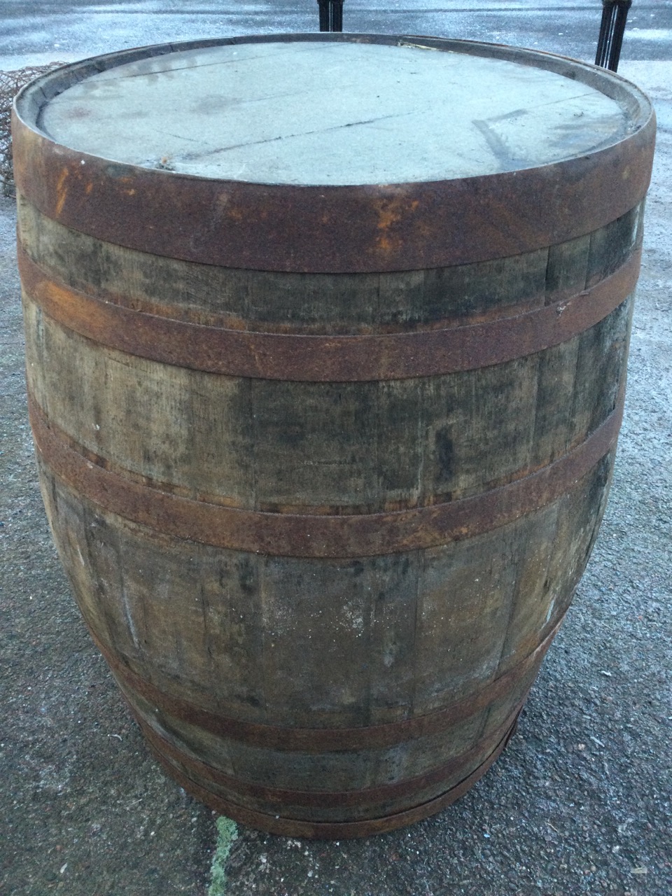 An old oak whiskey barrel, the staves bound by six riveted metal strap bands. (35in)