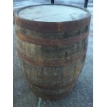 An old oak whiskey barrel, the staves bound by six riveted metal strap bands. (35in)
