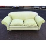 A drop-arm country house sofa with padded back and arms above loose cushions with sprung seat,