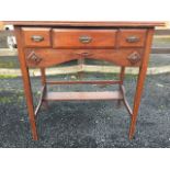 An oak arts & crafts side table, the rectangular chamfered top above three frieze drawers and arched