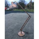 A giant anglepoise style lamp with bowl shade on sprung arms, raised on circular stepped weighted