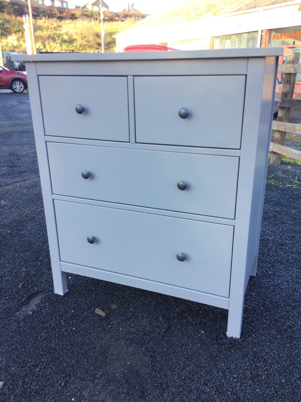 A modern painted chest of two short and two long graduated drawers mounted with metal knobs,