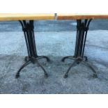 A pair of 2ft garden tables, the later hardwood tops on cast iron bases with nine rods beneath