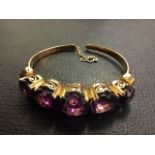 A Victorian 14ct gold amethyst bangle, with five graduated claw set stones in crown mounts with