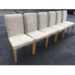 A set of six contemporary oak dining chairs with suede upholstery and sprung seats, raised on square