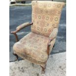 A nineteenth century upholstered armchair with tapering back and crook arms with elbow pads, the