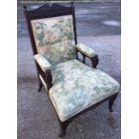 A carved late Victorian armchair, the back with scrolled crest above a fluted rail with