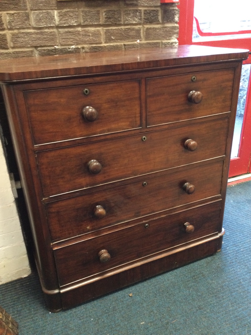 A Victorian mahogany chest of drawers, the rectangular rounded top above two short and three long