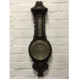 A Victorian carved oak barometer by Fattorini & Sons Ltd, the silvered dial under bevelled glass