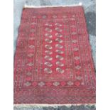 An Afghan rug woven with field of eighteen octagonal lozenges within multiple floral borders, the