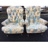 A pair of Victorian style button upholstered armchairs covered in floral linen, having loose