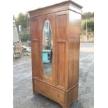 An Edwardian mahogany wardrobe with moulded cornice above a central oval bevelled mirror door