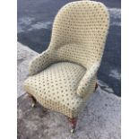 A small Victorian spoonback upholstered armchair, the sprung seat raised on turned legs with brass