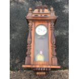 A walnut cased Vienna wallclock, the pediment with finials and applied mouldings above an arched