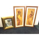 A pair of framed prints of African ladies in traditional dress, one carrying an infant; and a framed