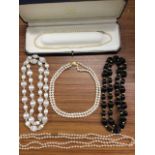 A cased double-strand pearl choker with 9ct gold bun shaped embossed clasp; a pair of silk black &