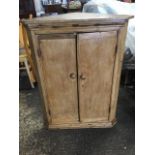 A nineteenth century pine corner cabinet, with moulded cornice above plain knobbed doors enclosing