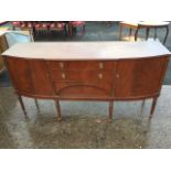 A reproduction mahogany sideboard, the shaped top with ribbed edge above three central drawers,